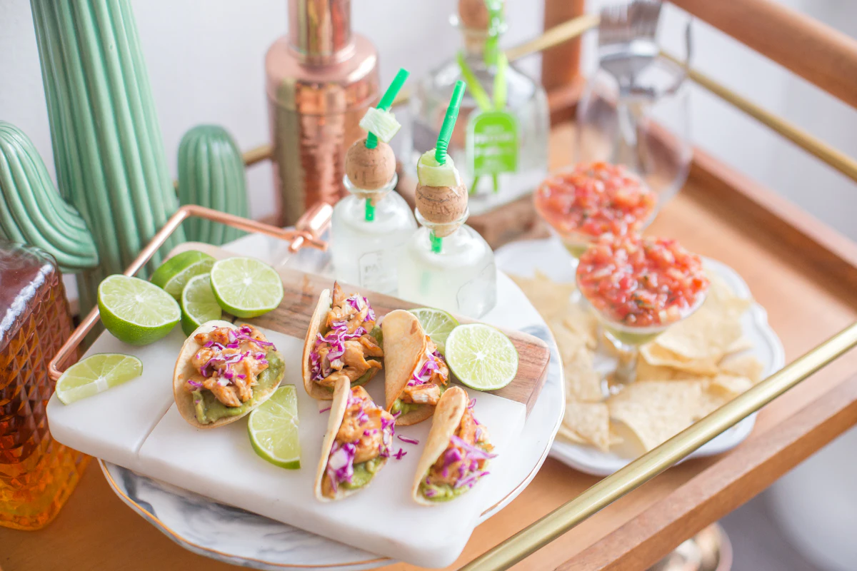 Tacos, lime wedges, salsa and tortilla chips set out on a party drinks trolley